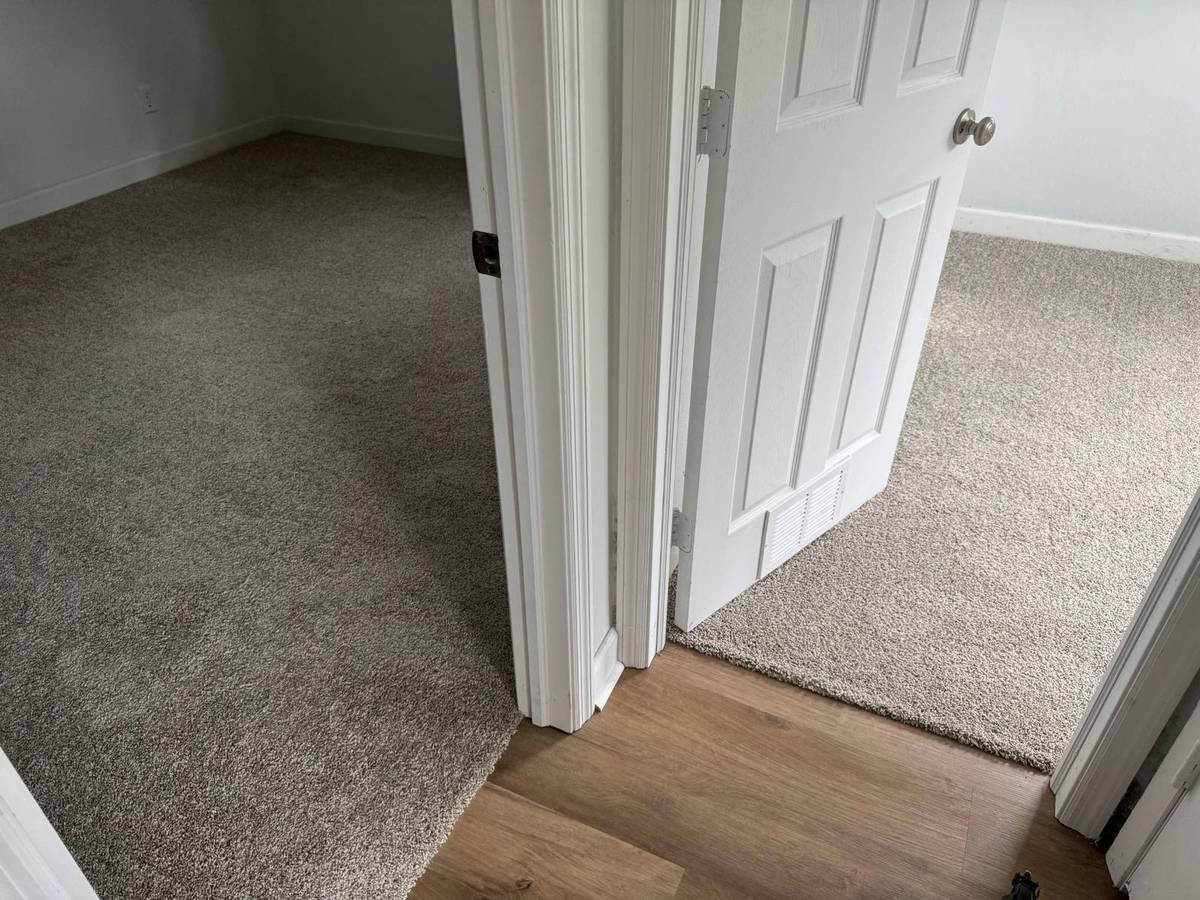New carpet in two bedrooms meeting vinyl plank in the hallway of a San Jose Jacksonville home