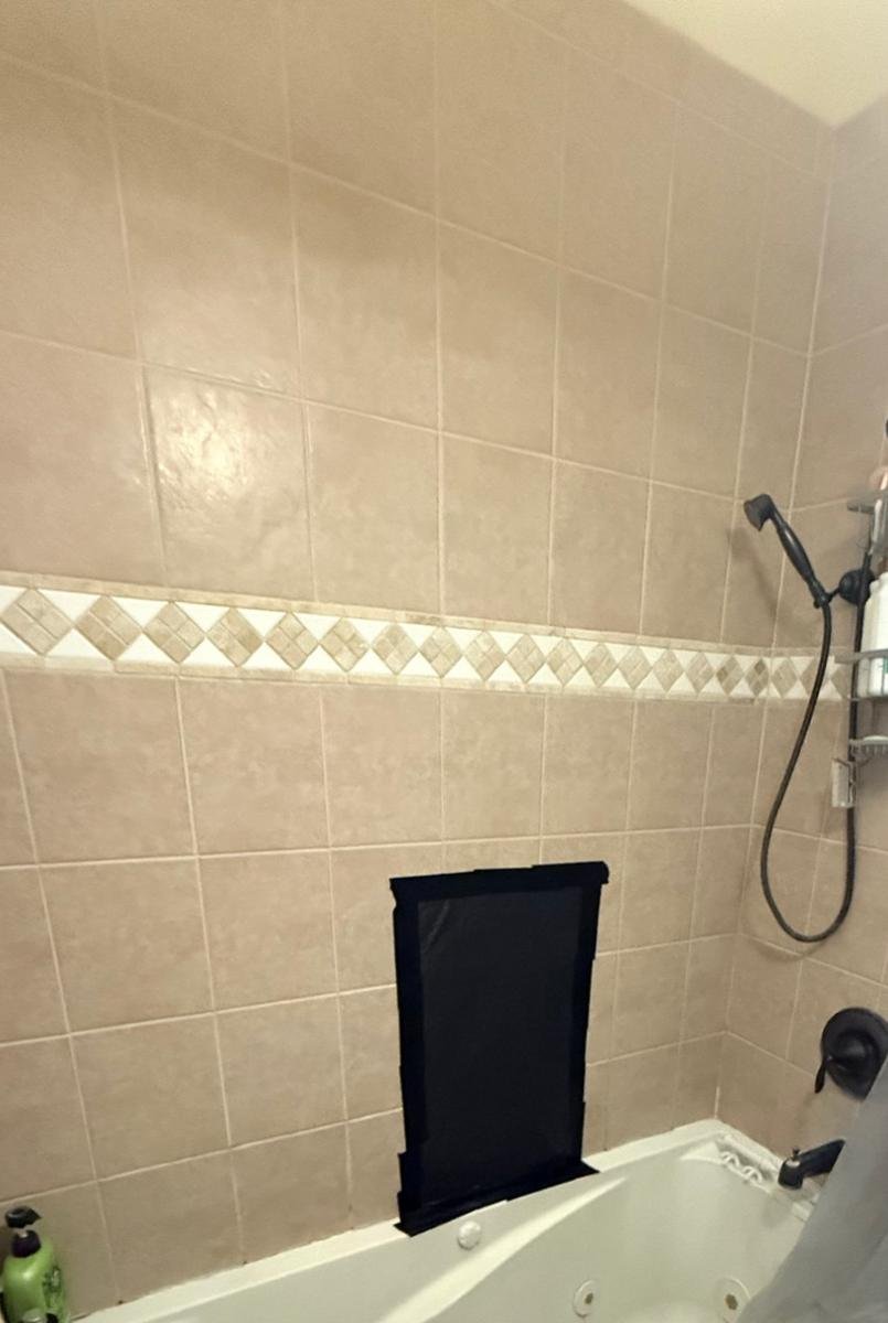 Old tub surround tile in a Mandarin, Jacksonville bathroom before replacement