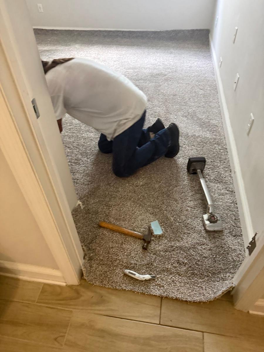 Gator Carpet and Tile installer James fitting carpet with a knee kicker