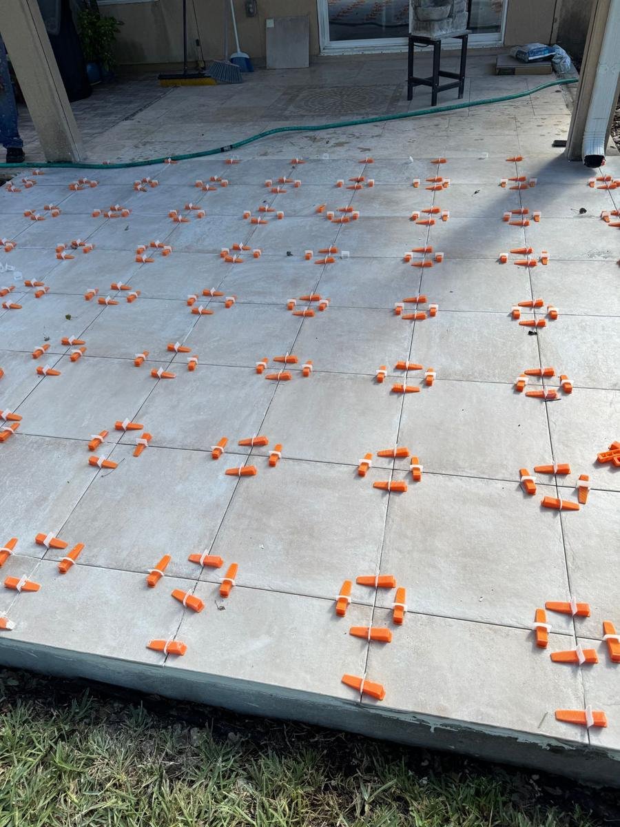 Tile leveling clips holding outdoor porcelain flat during a patio install in World Golf Village, St. Augustine, FL